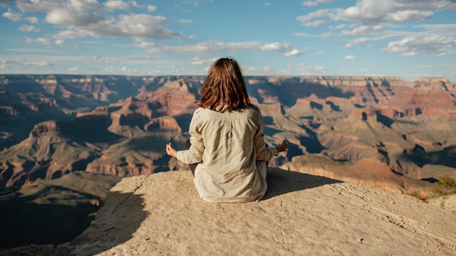 Frau auf Berg, die mit Pinterest-Marketingstrategie Meditation anbietet